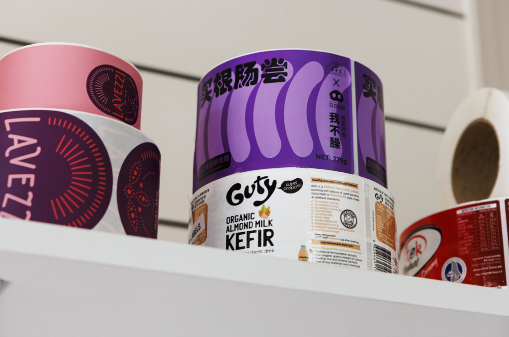 Rolls of red, purple and white labels on a shelf.